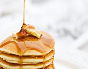 syrup pouring over pancakes