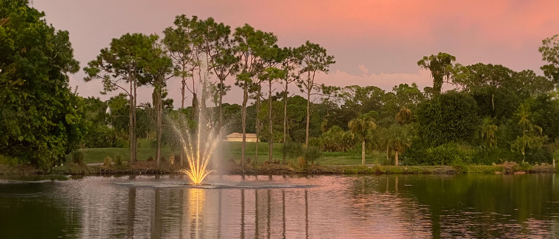 pond with fountain against a rose gold sunset